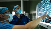 Navy doctors reviewing medical scans on a monitor, analyzing diagnostic images for patient care.