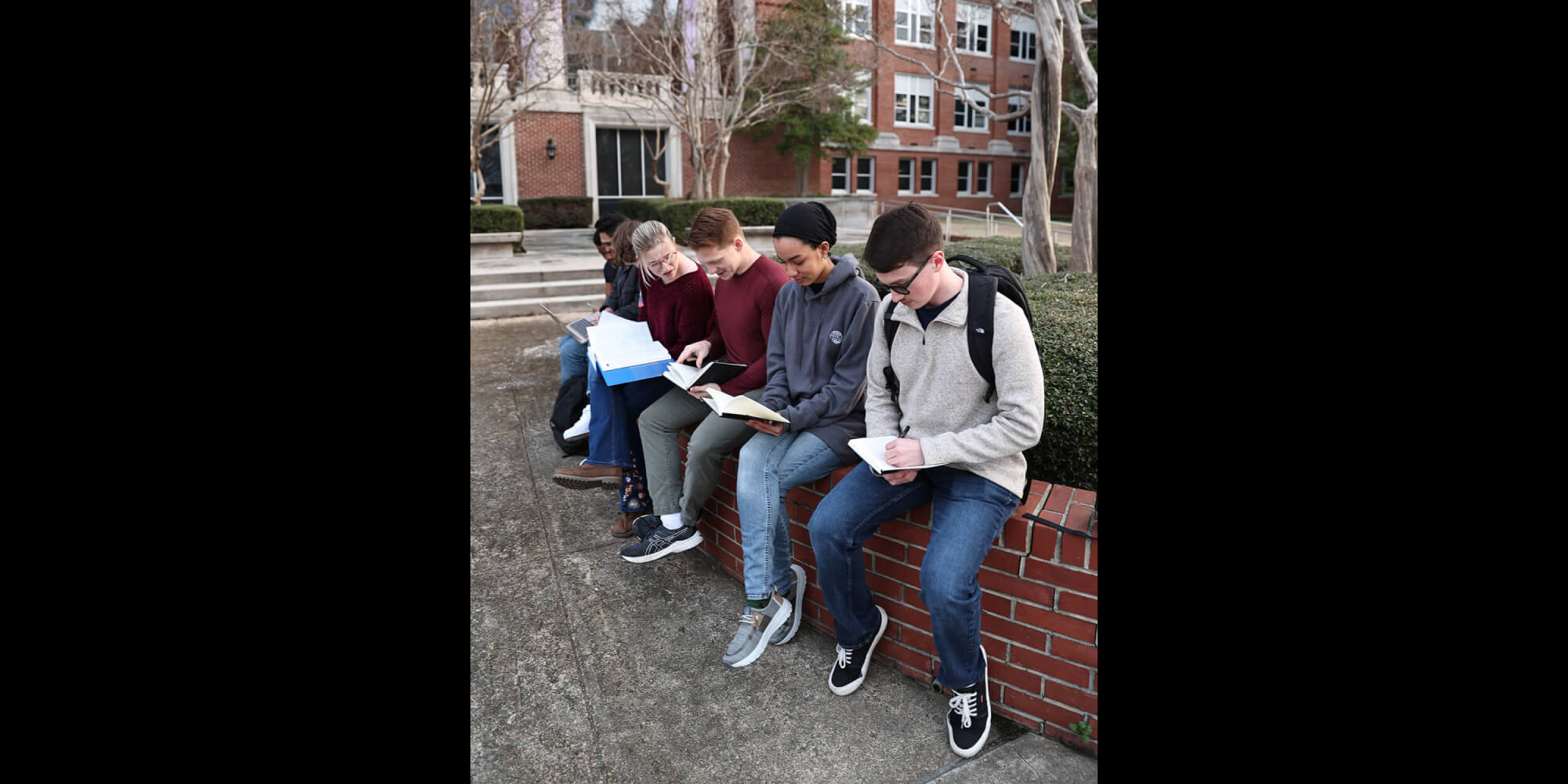 Students studying on campus, researching future options like Navy Benefits.